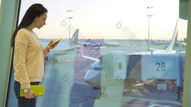 航空公司乘客机场休息室等待飞行飞机高加索人女人说话手机大窗口背景大飞机